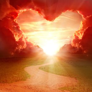 Red heart shaped sky at sunset. Beautiful landscape with road.Love background with copy space. Road to love
